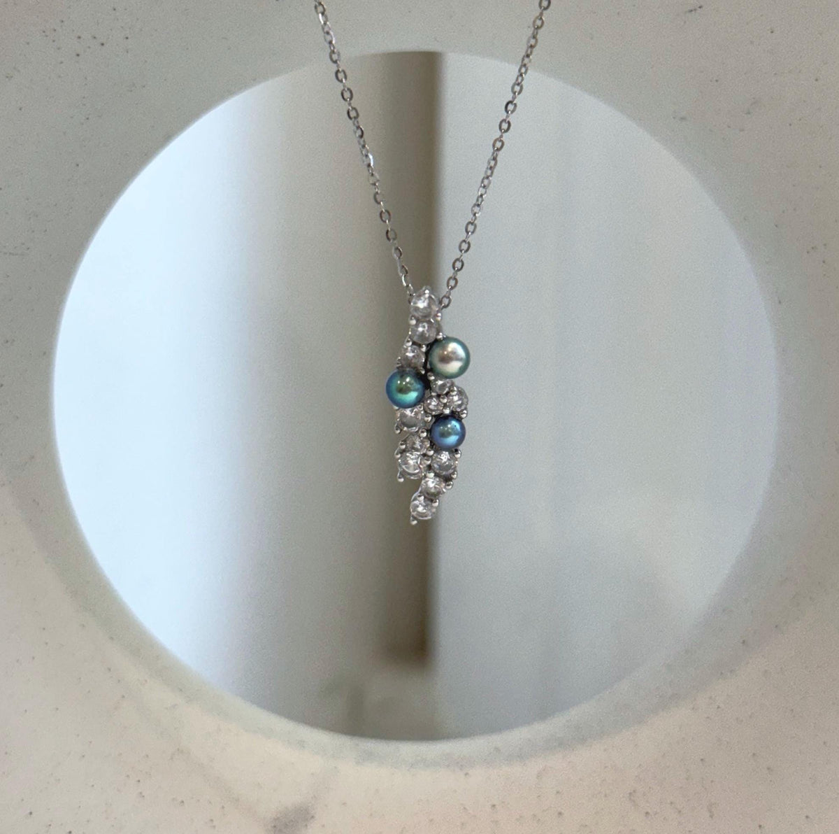 Peacock pearl pendant with a delicate silver leaf design