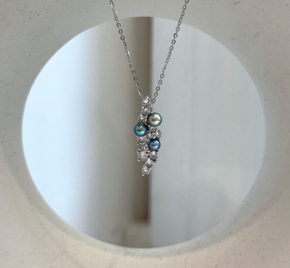 Nature-inspired silver pendant with peacock pearls
