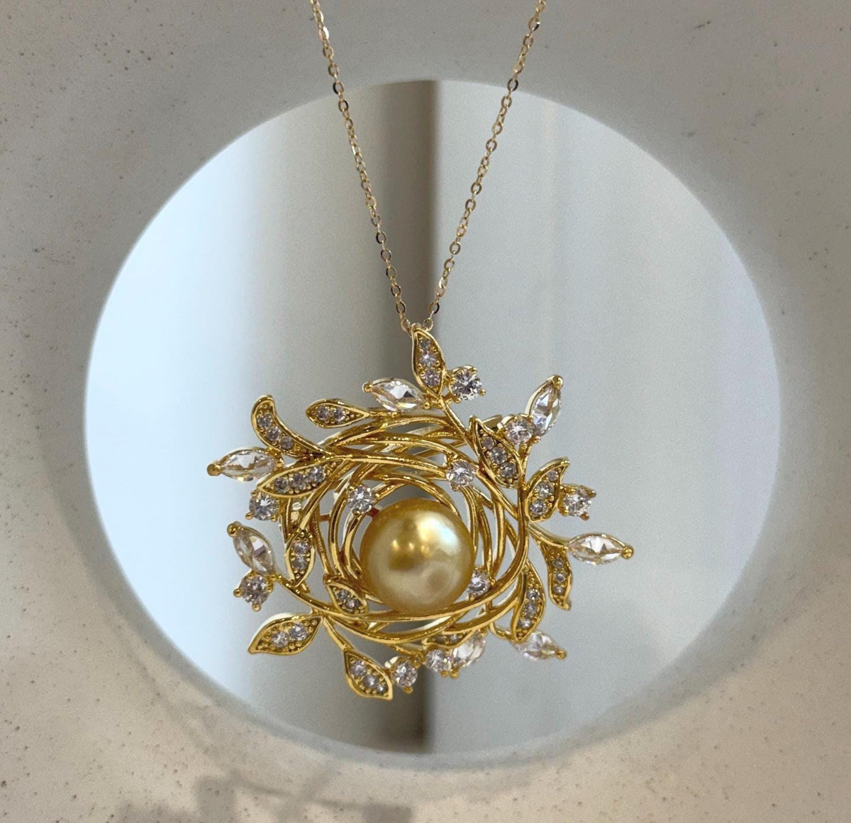 Golden South Sea pearl at the center of an ornate wreath