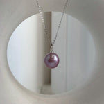 Purple Edison pearl jewelry set displayed beside a textured stone.
