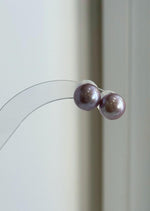 Edison pearl pendant and earrings with reflective pink and purple hues.
