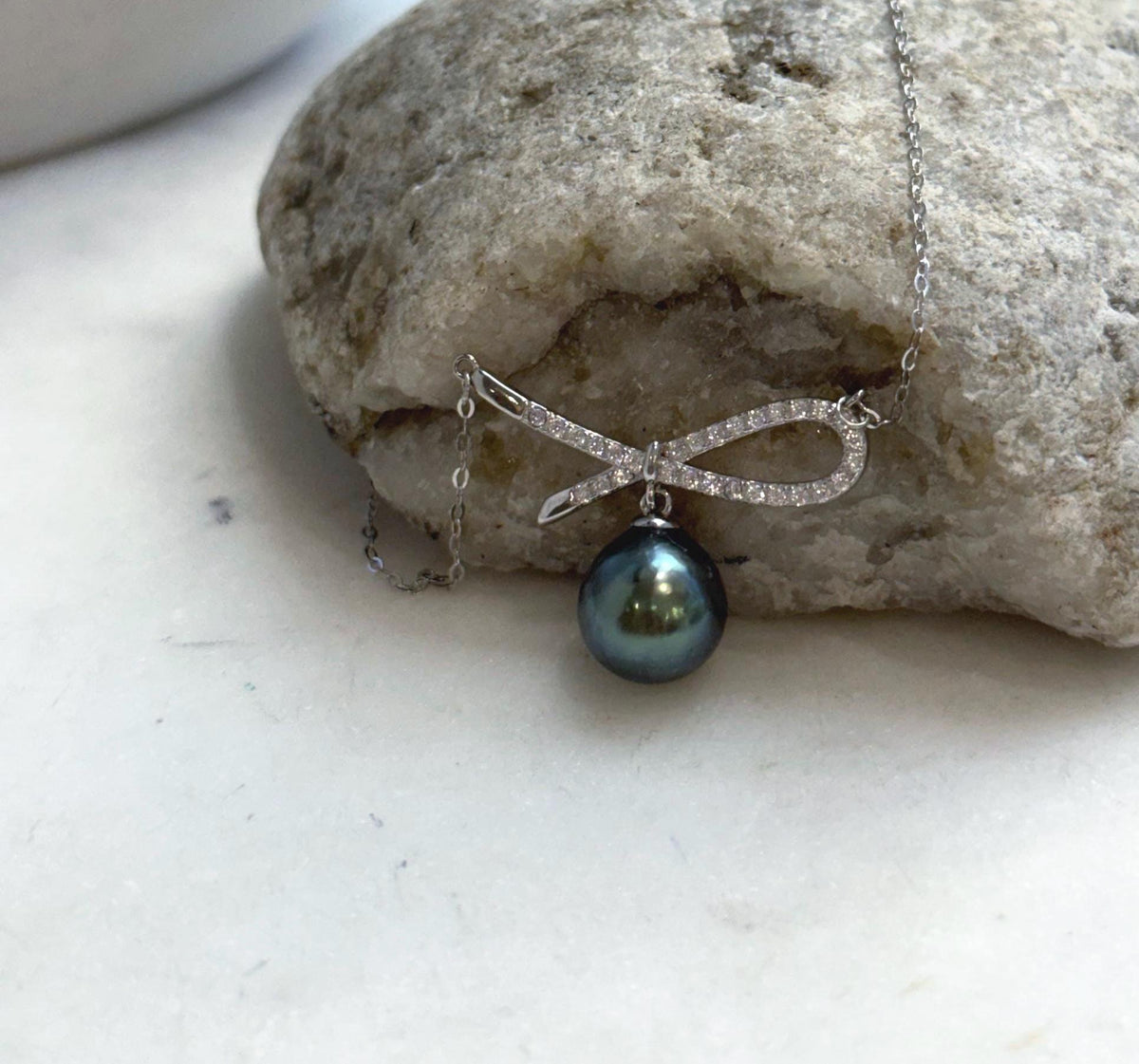 Silver bow necklace with a genuine Tahitian pearl and a fine oval-link chain.