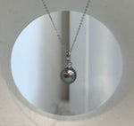 Peacock green pearl pendant framed by crystal-accented sterling silver.