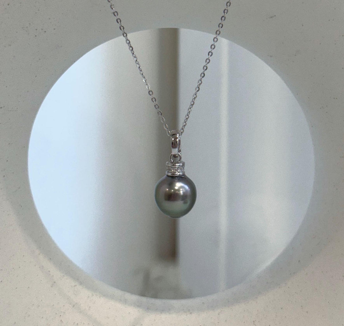 Peacock green pearl pendant framed by crystal-accented sterling silver.