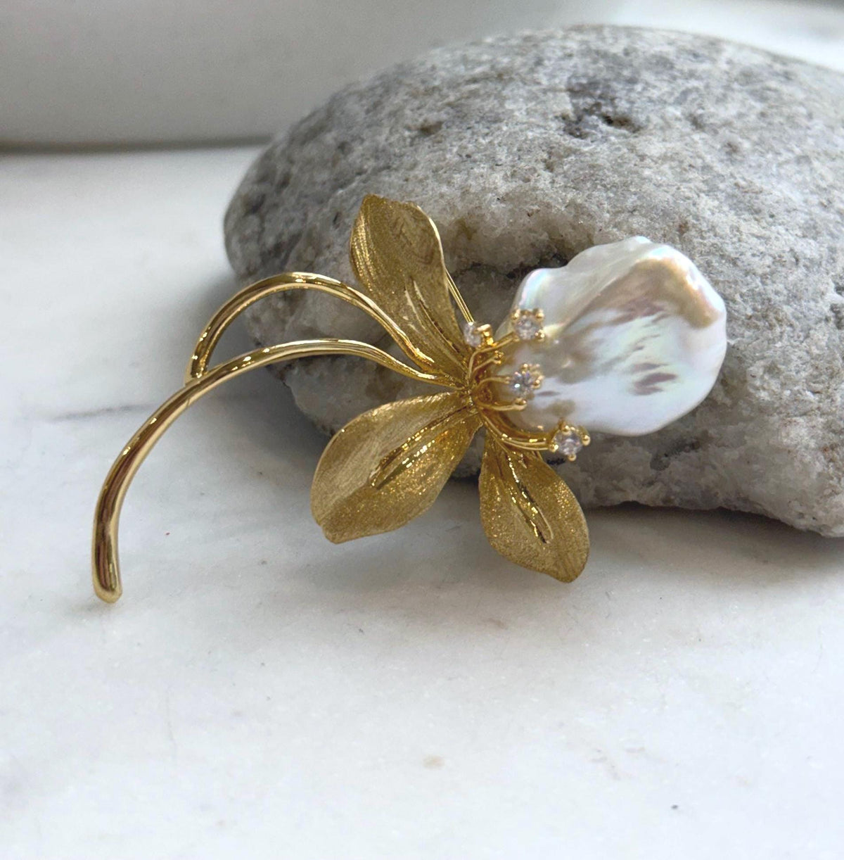 White baroque pearl flower brooch with sparkling accents.