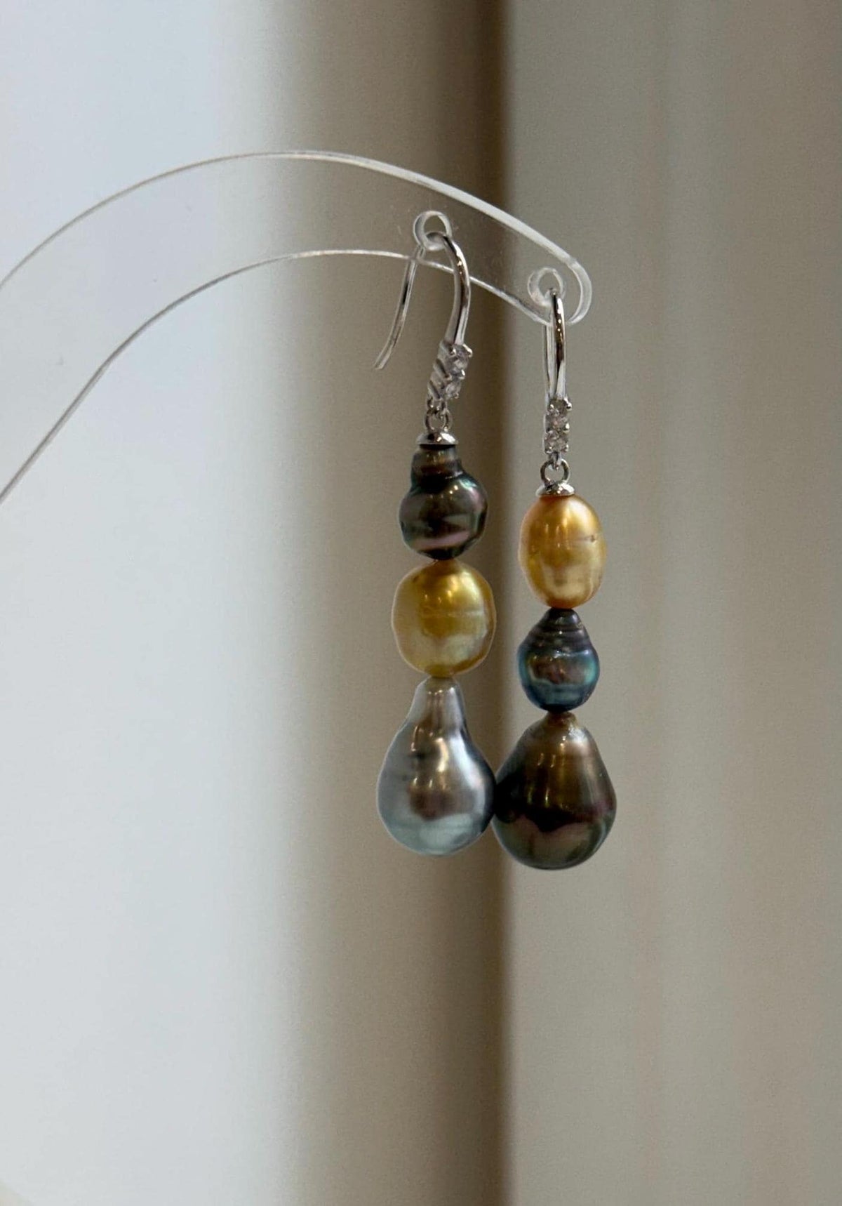 Ocean pearl earrings featuring three lustrous pearls on each silver hook.