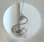 Swan brooch with a black eye and clear teardrop-shaped crystal accents.