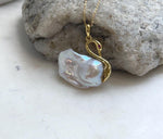 Iridescent pearl necklace with a graceful gold-tone swan design.