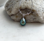 Teardrop Tahitian pearl pendant with mirror luster suspended from a curved row of sparkling silver flowers.