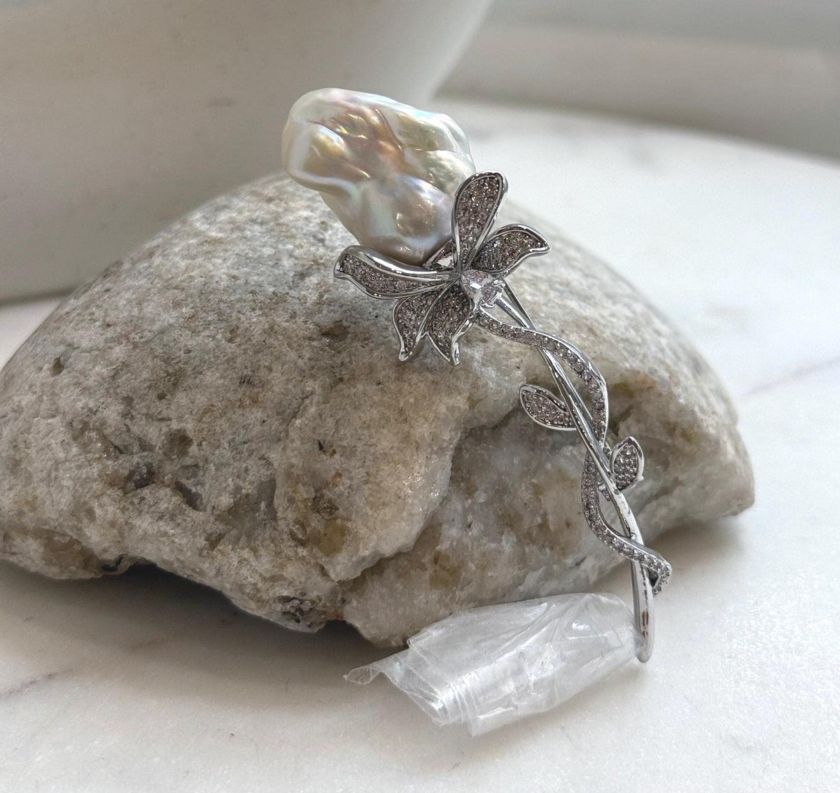 White baroque pearl floral brooch with crystal-accented silver-tone vines.