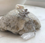 Silver-tone vine brooch showcasing an organically shaped white baroque pearl.