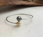 Champagne gold ocean pearl paired with a platinum gray pearl on a silver bracelet.