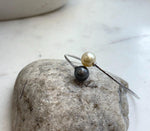 Two lustrous ocean pearls accent a slender sterling silver bangle.
