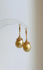 Pair of ultra golden South Sea pearl drops with warm tones and reflective luster.