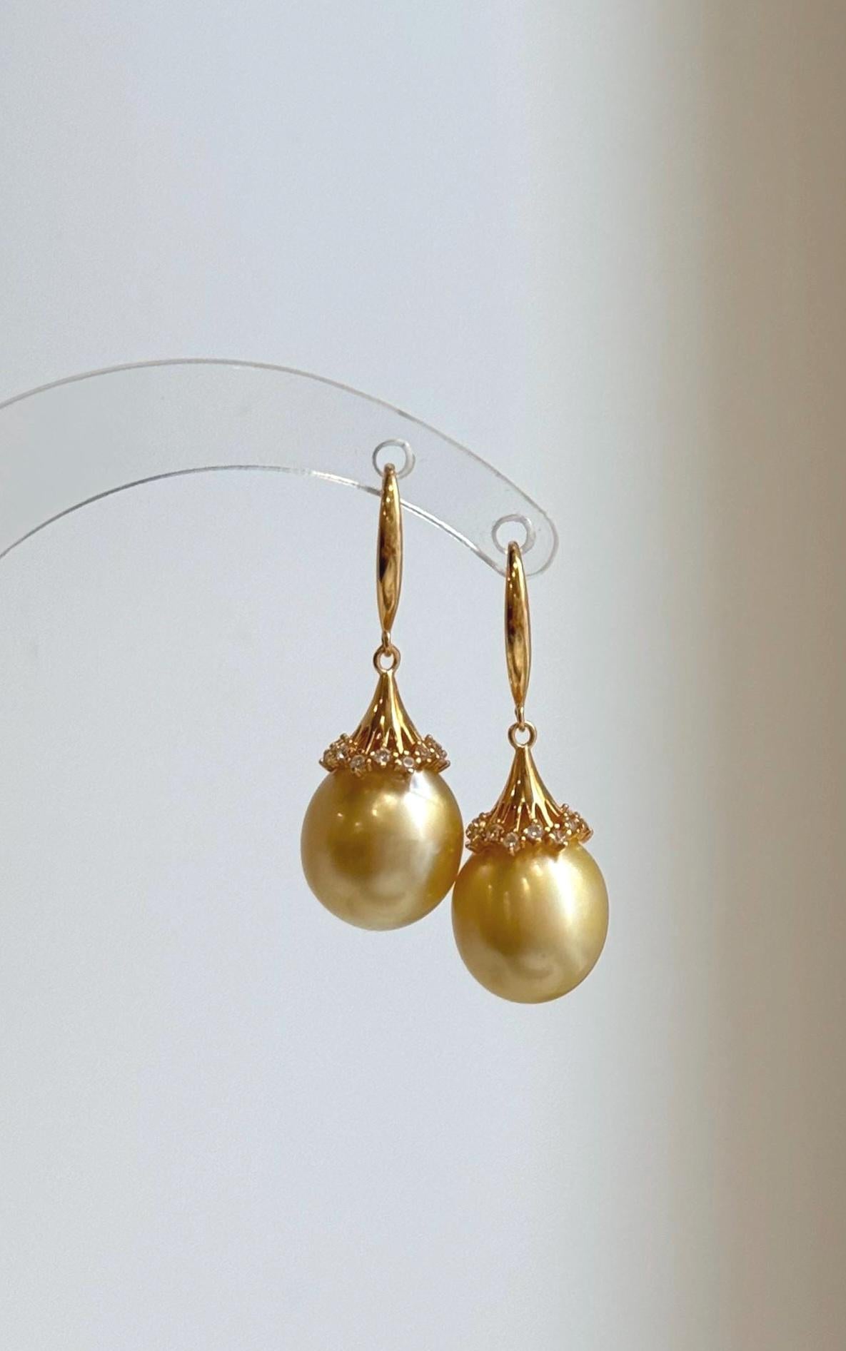 Pair of ultra golden South Sea pearl drops with warm tones and reflective luster.