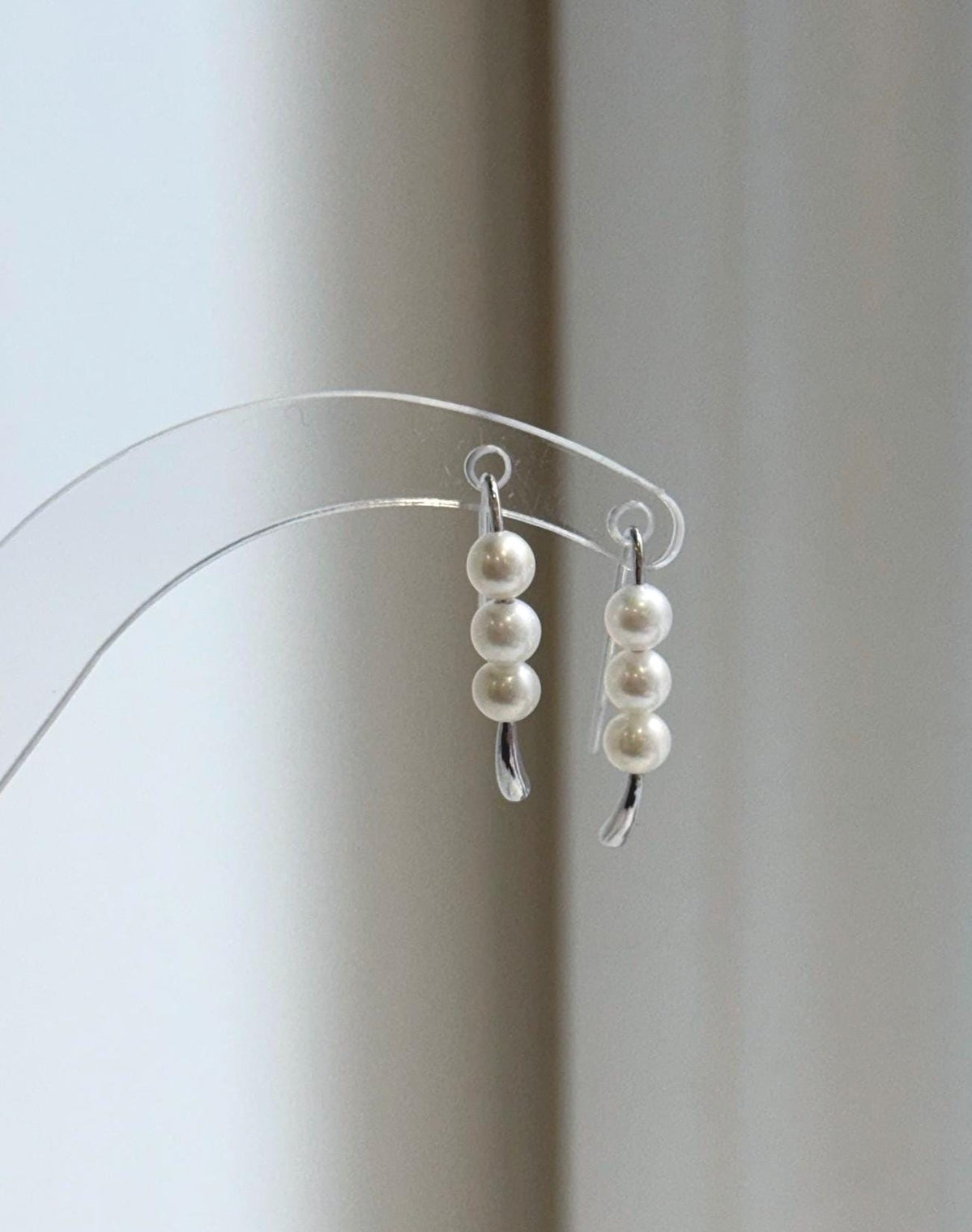 White triple pearl earrings with minimalist curved S925 sterling silver hooks.