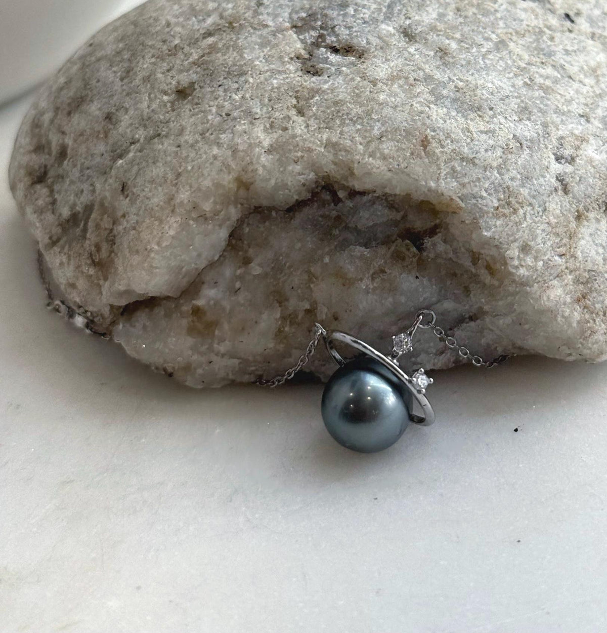 Celestial pearl necklace with a star detail positioned asymmetrically along the sterling silver chain.