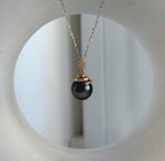 Genuine Tahitian saltwater pearl framed by a curved gold-tone snake design.