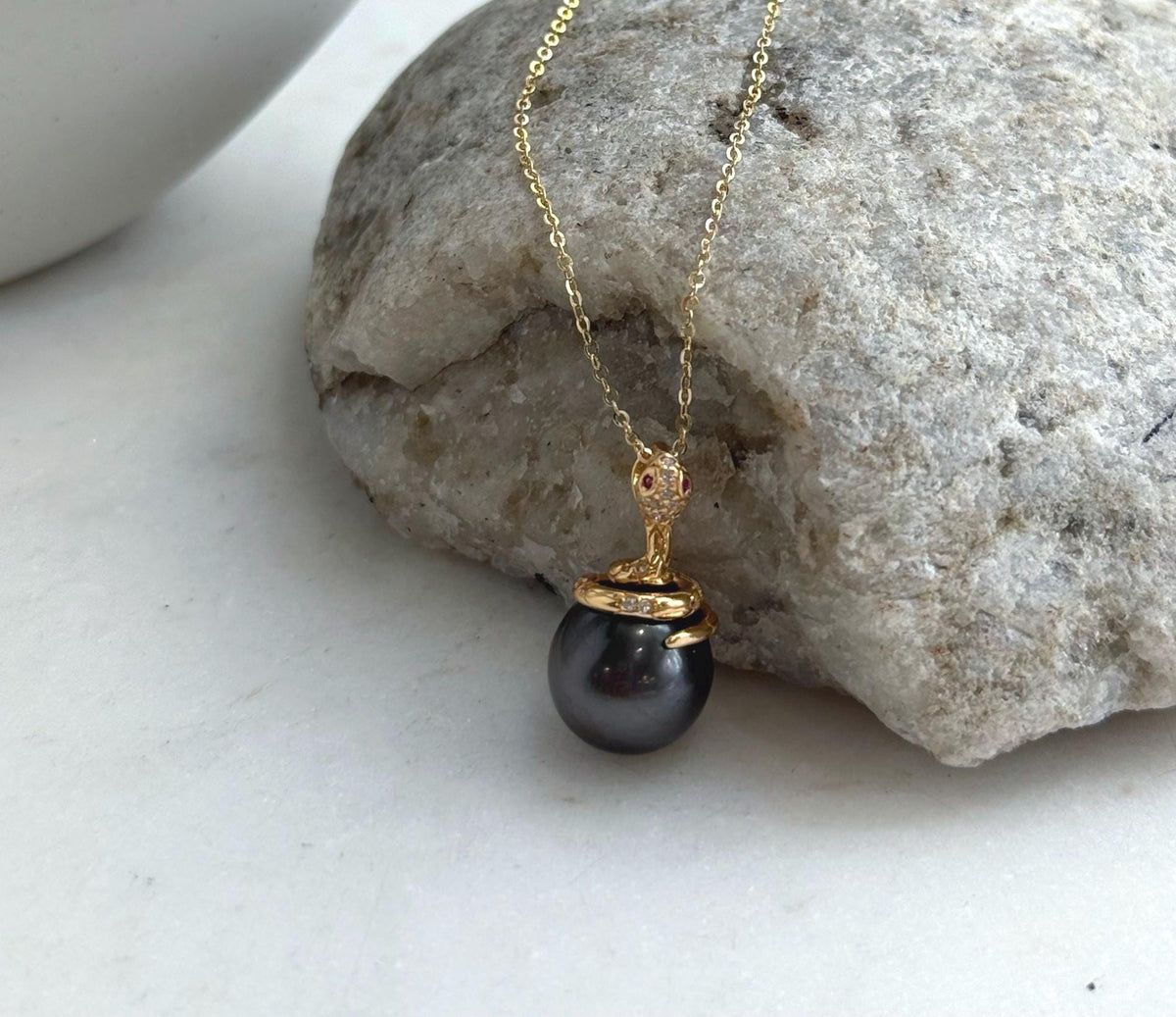 Black pearl snake pendant with sparkling accents on the gold-tone snake head.