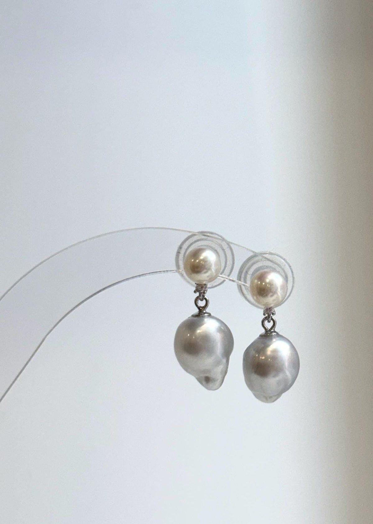 Pearl drop earrings featuring creamy white and silvery reflective surfaces.