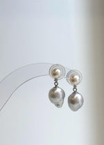 Pearl drop earrings featuring creamy white and silvery reflective surfaces.