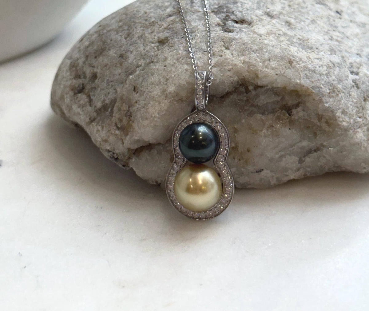 Two lustrous saltwater pearls forming a gourd-shaped silver pendant.