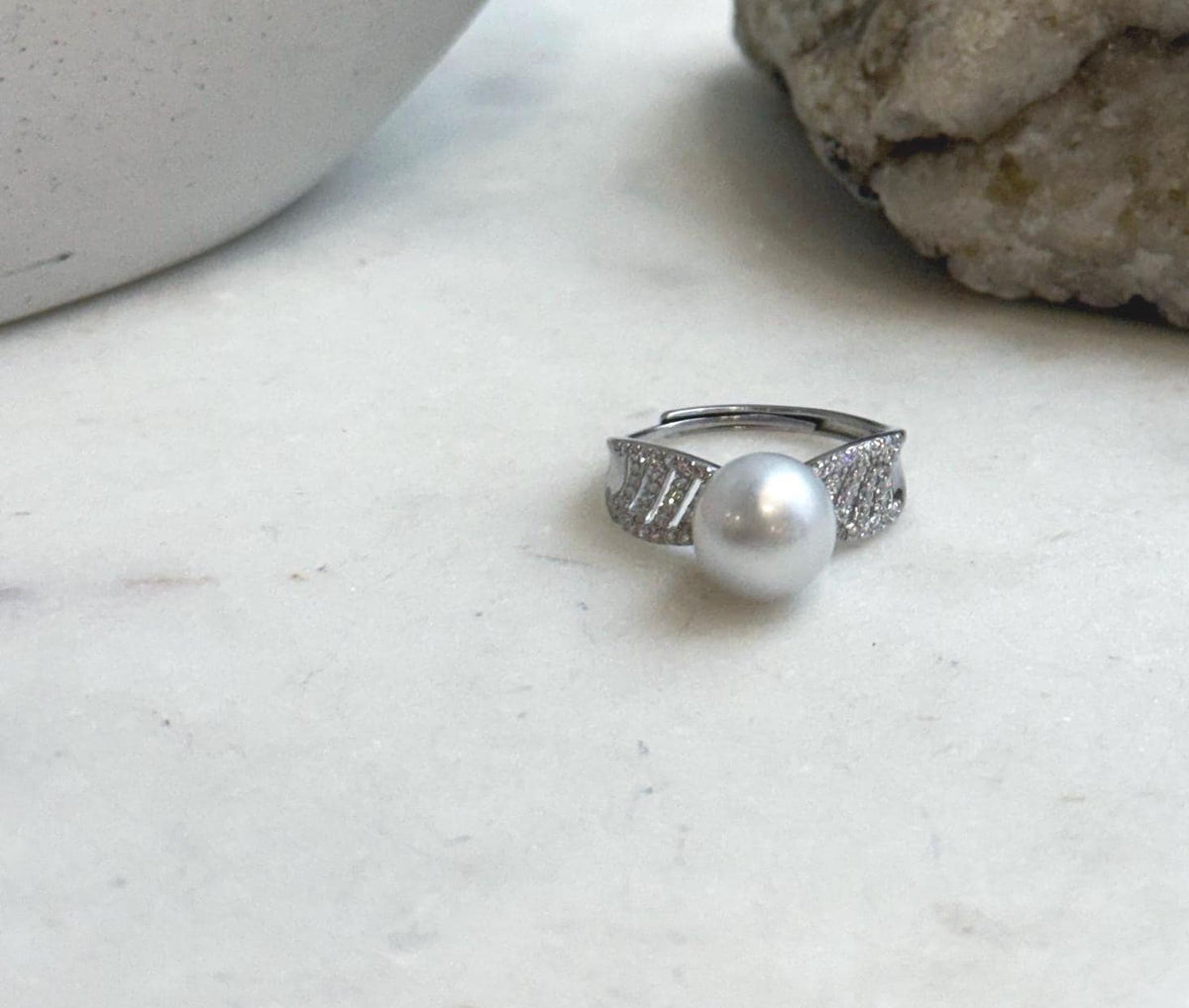 Australian white South Sea pearl ring resting on a clear bag with handwritten measurements.