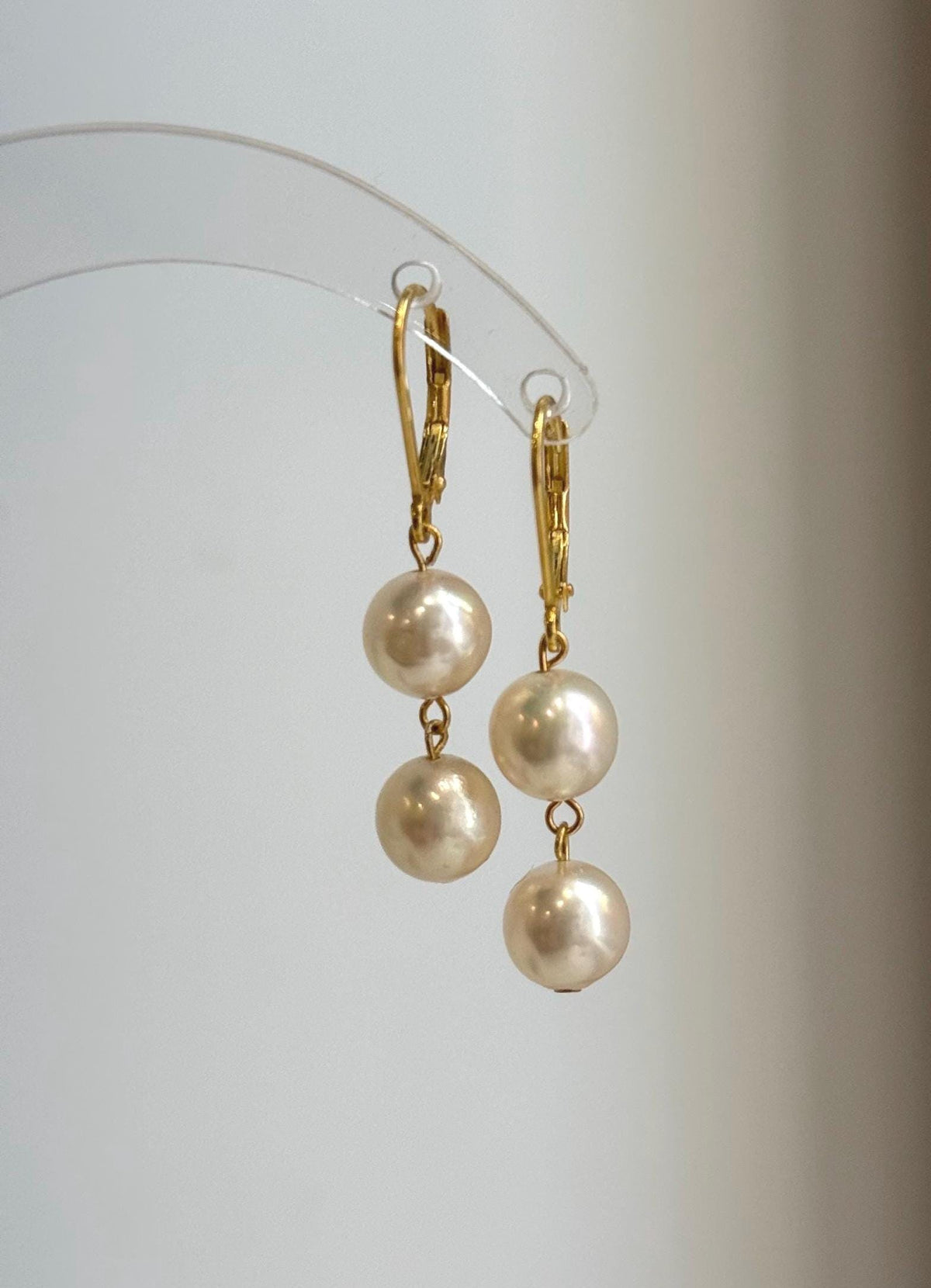 Two Akoya pearls linked vertically beneath each gold-plated sterling silver clasp.