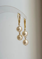 Two Akoya pearls linked vertically beneath each gold-plated sterling silver clasp.