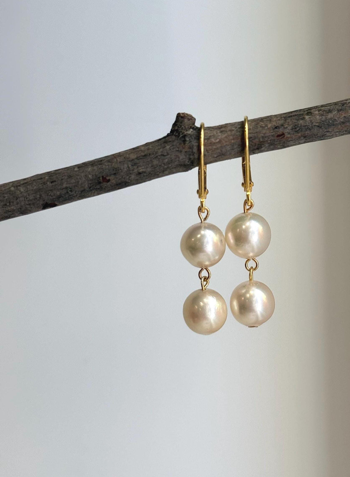 Akoya saltwater pearl earrings with small gold-plated links connecting the pearls.