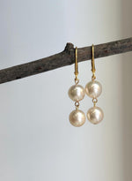 Akoya saltwater pearl earrings with small gold-plated links connecting the pearls.