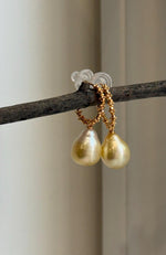 Lustrous golden ocean pearl earrings with silver hook fittings.