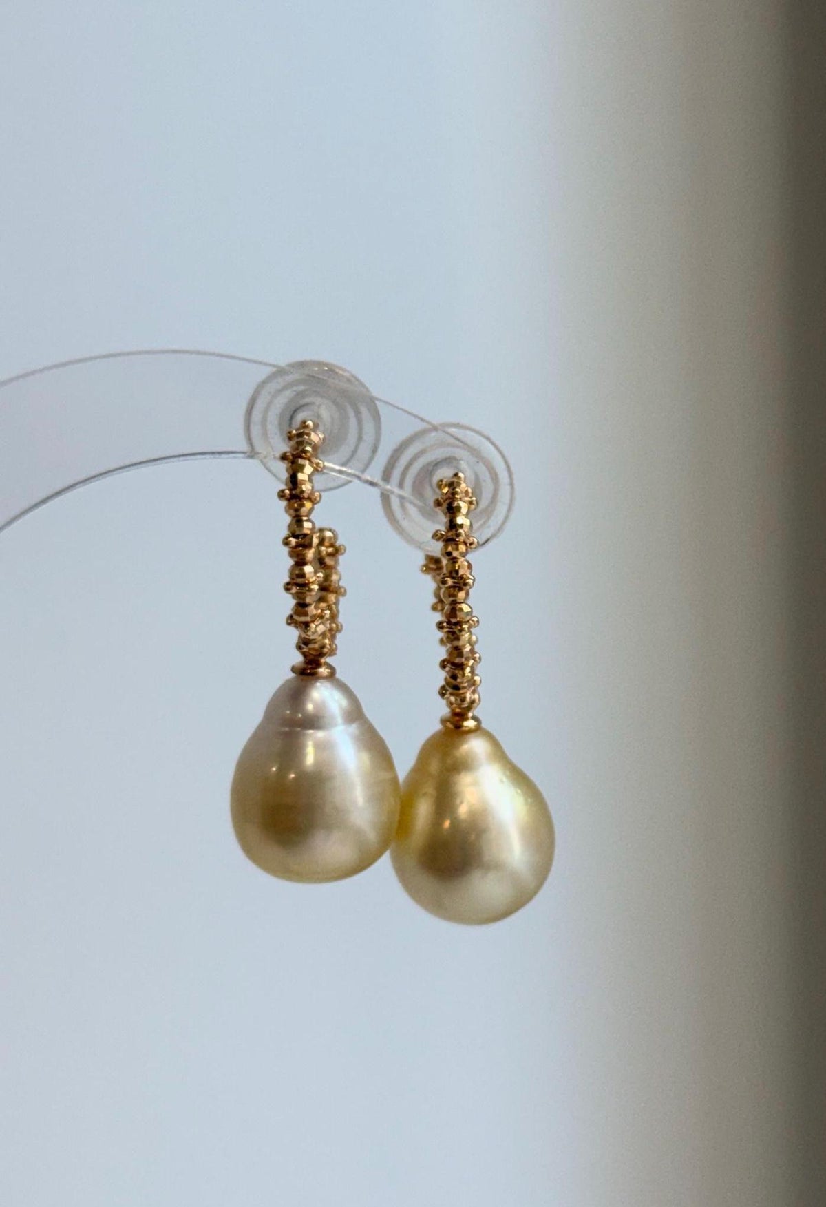 Mirror-luster golden pearl drops hanging from S925 silver hooks.
