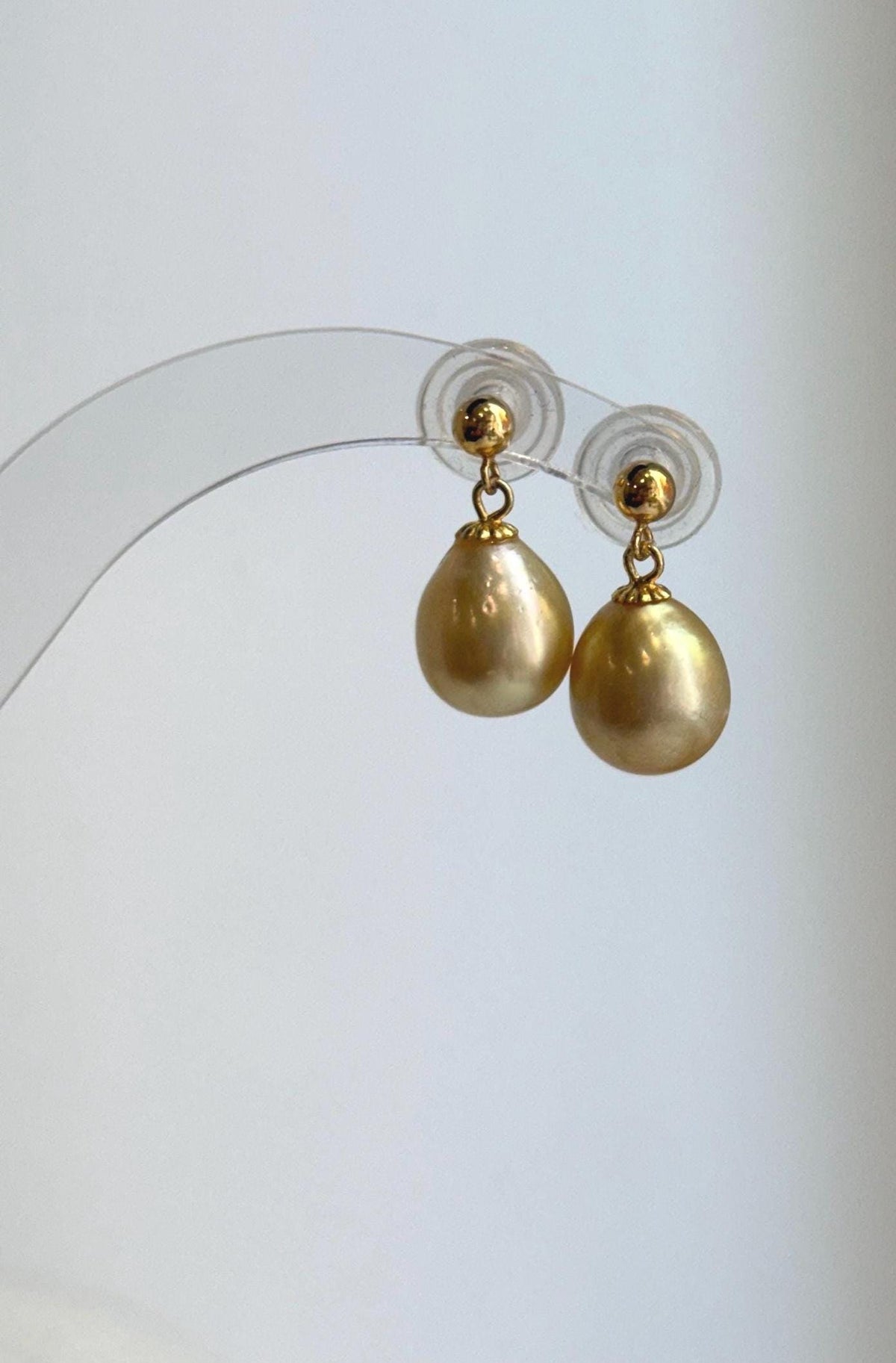 Lustrous golden pearl drops with delicate gold-tone caps.