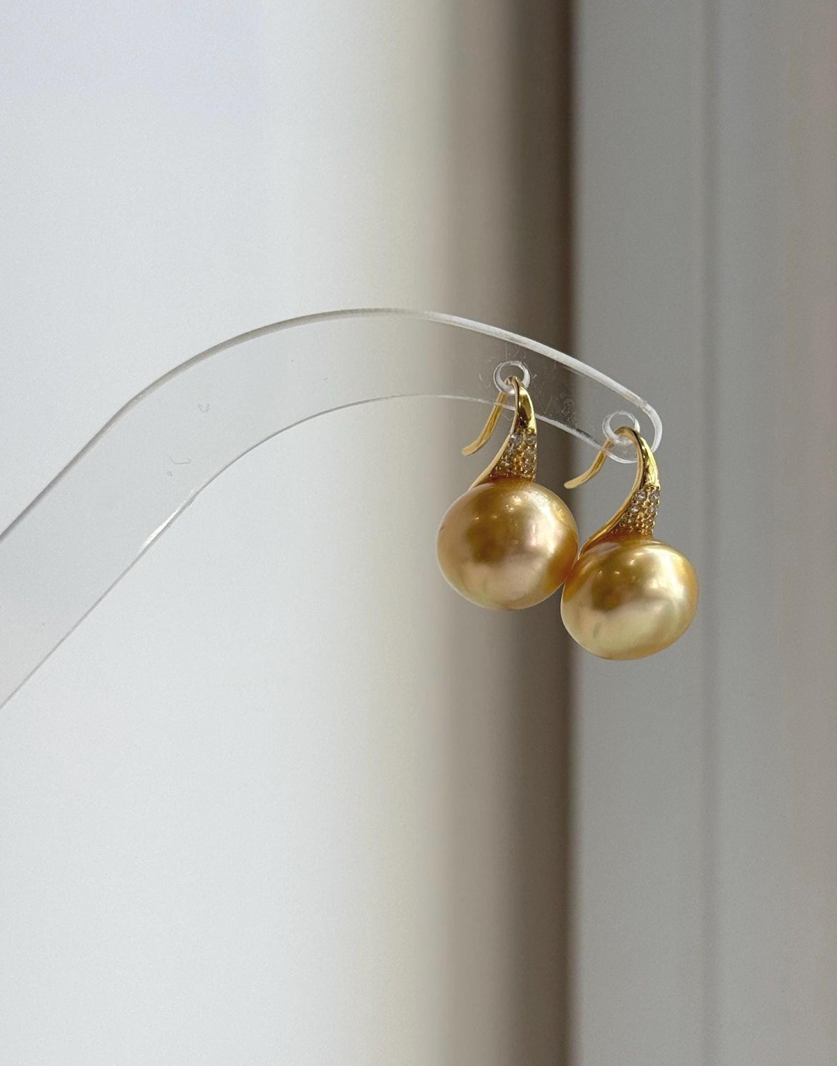 Deep tea golden saltwater pearls suspended from high-heel inspired ear hooks.