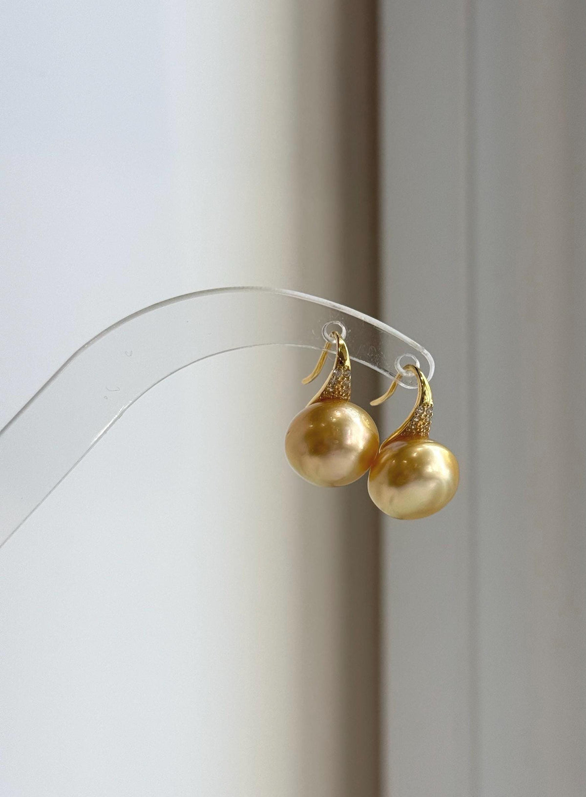 Golden South Sea pearl earrings combining reflective pearls and high-heel style silver hooks.