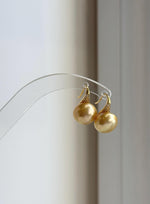 Golden South Sea pearl earrings combining reflective pearls and high-heel style silver hooks.