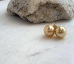 South Sea pearl drop earrings showcasing rich golden color and mirror-like reflections.