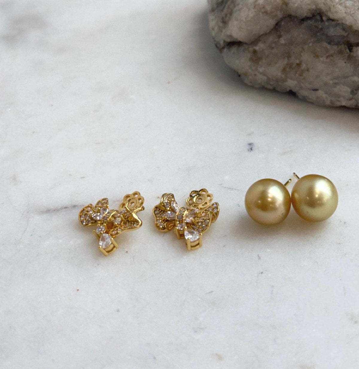Tea golden saltwater pearl studs with lustrous surfaces and silver settings.