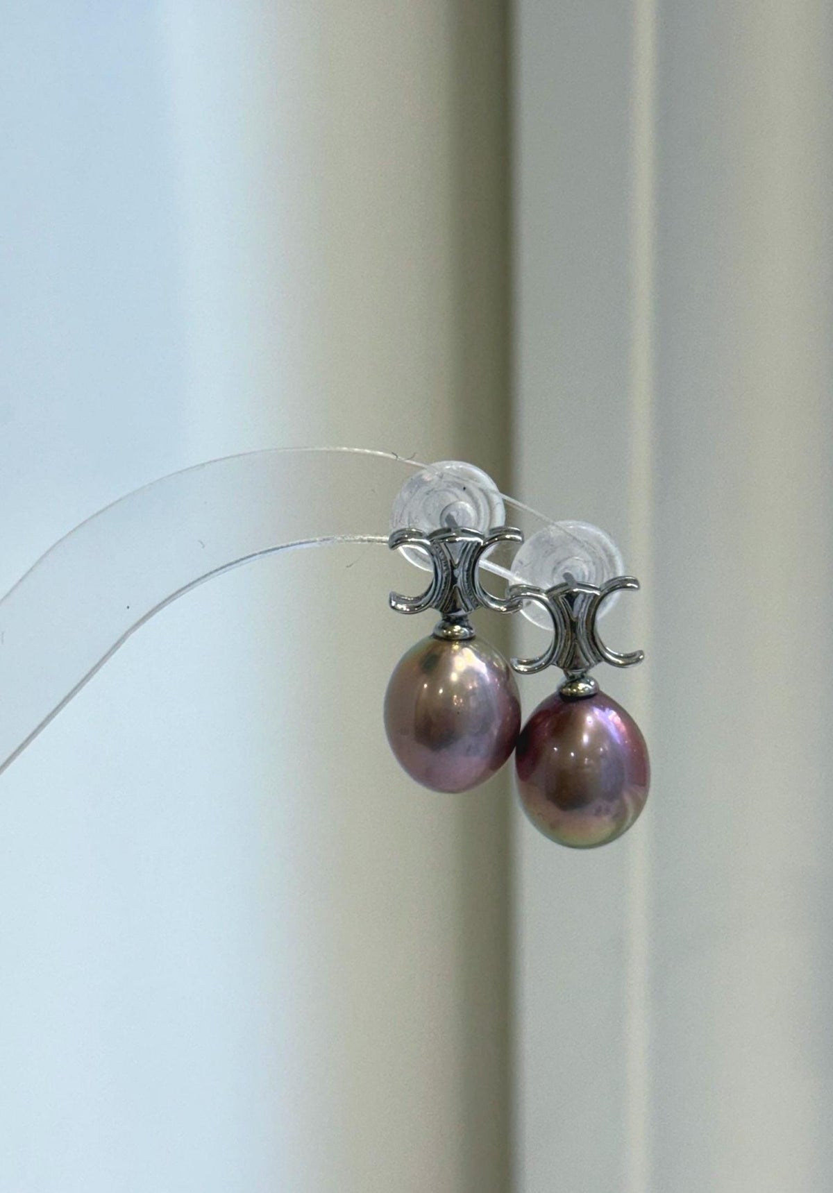 Rose purple Edison pearl earrings with highly reflective surfaces.