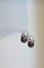Dual pearl stud earrings featuring dark Tahitian pearls beneath smaller white freshwater pearls.