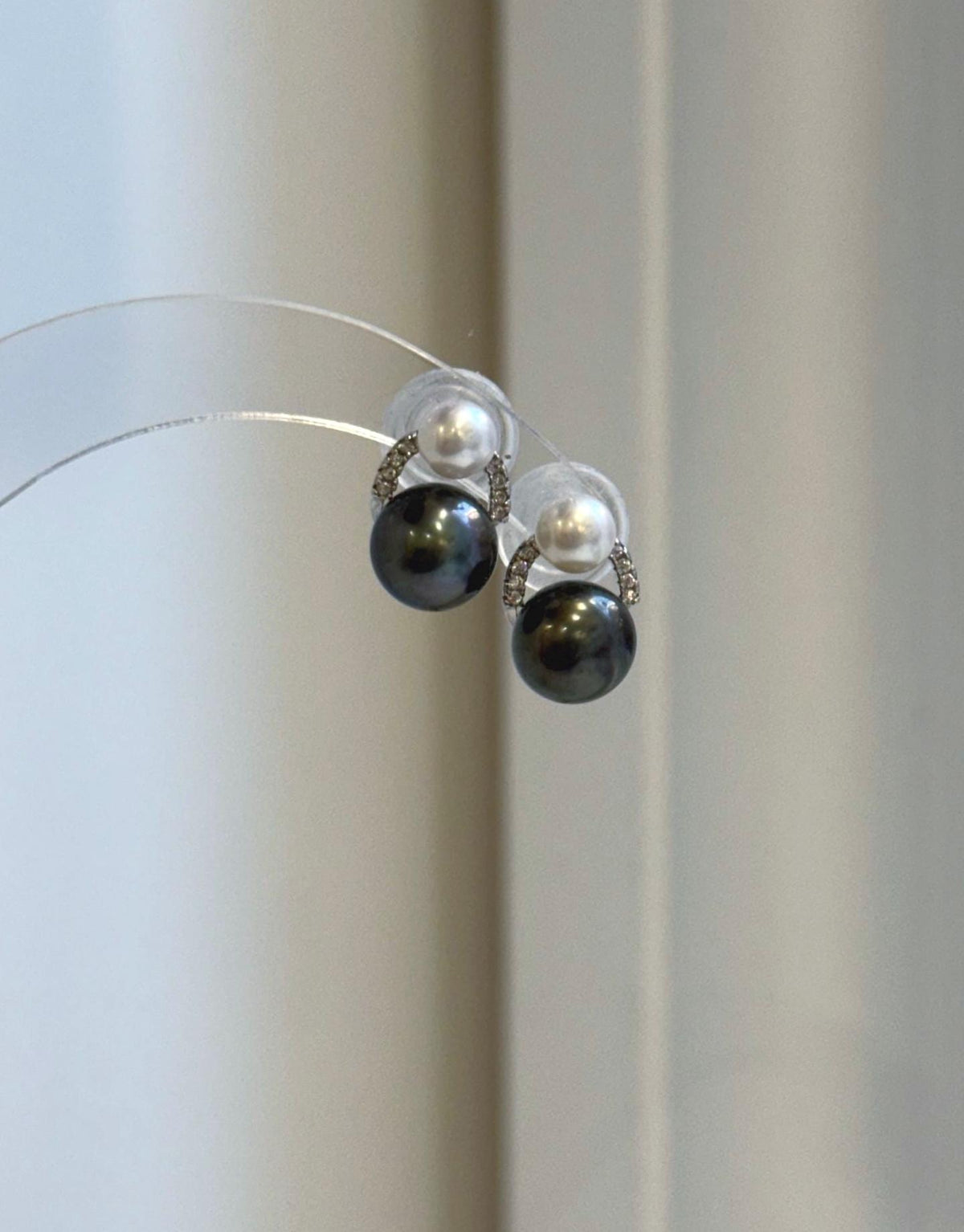 Tahitian pearl stud earrings with white freshwater pearl tops and silver settings.