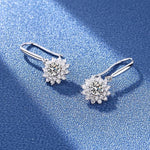 Sterling silver floral earrings with clear faceted stones arranged around round moissanite centers.