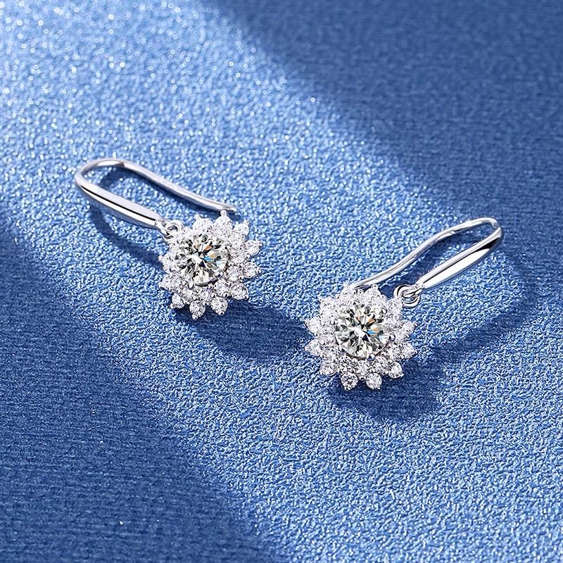 Sterling silver floral earrings with clear faceted stones arranged around round moissanite centers.