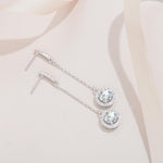 S925 sterling silver dangle earrings featuring stone-set tops and round halo pendants.