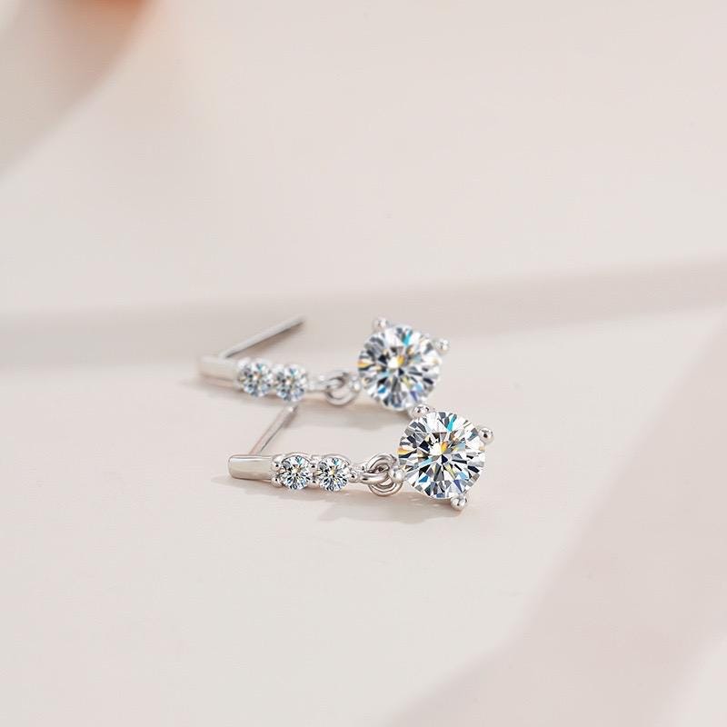 Round moissanite stones suspended from polished silver tops with delicate accent stones.