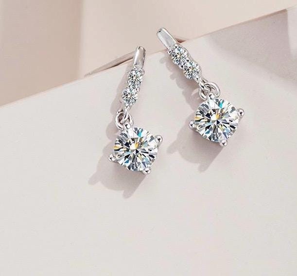 Moissanite drop earrings with round brilliant center stones and S925 sterling silver settings.