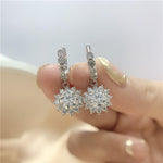 S925 sterling silver earrings featuring stone-set hoops and floral moissanite drops.