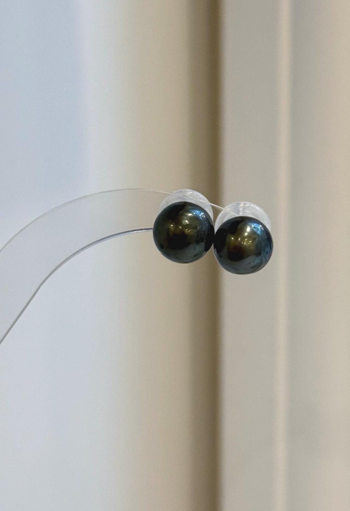 Lustrous Tahitian pearls suspended beneath minimalist sterling silver stud settings.