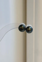 Lustrous Tahitian pearls suspended beneath minimalist sterling silver stud settings.